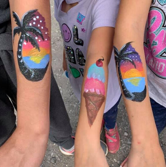 three arms, painted with an ice cream cone and a tropical sunset with palm trees