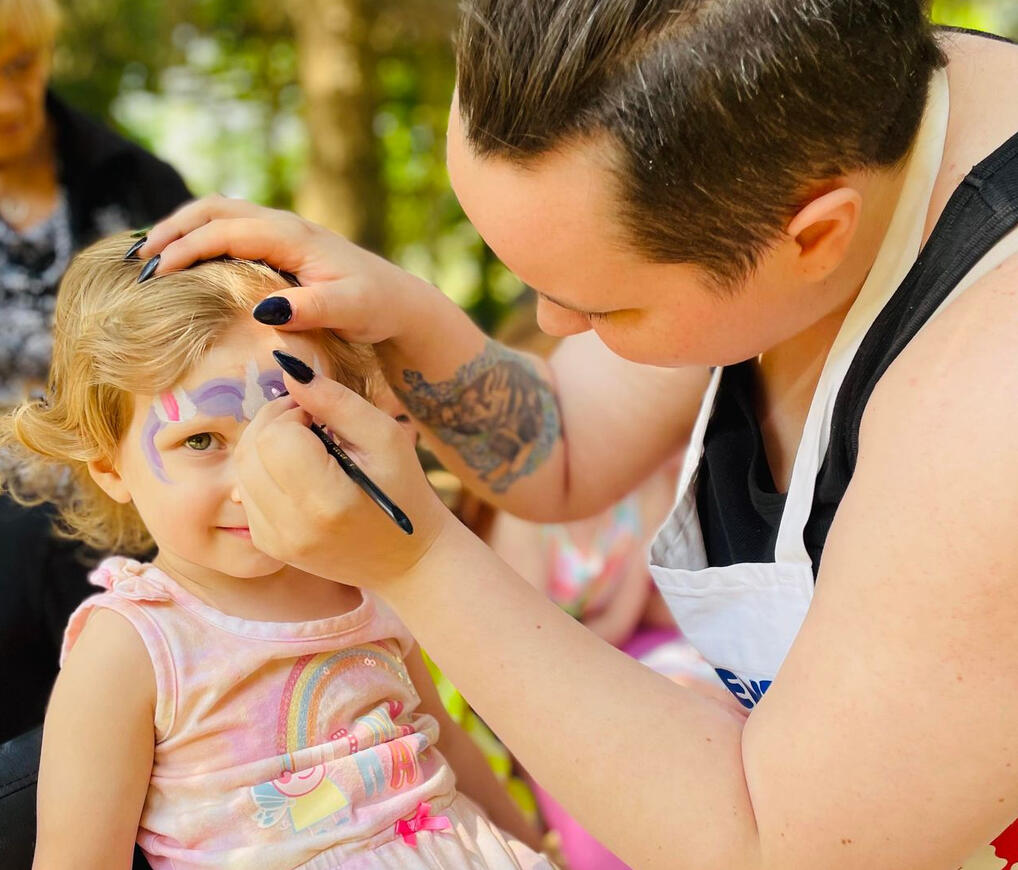 young girl being painted as a unicorn